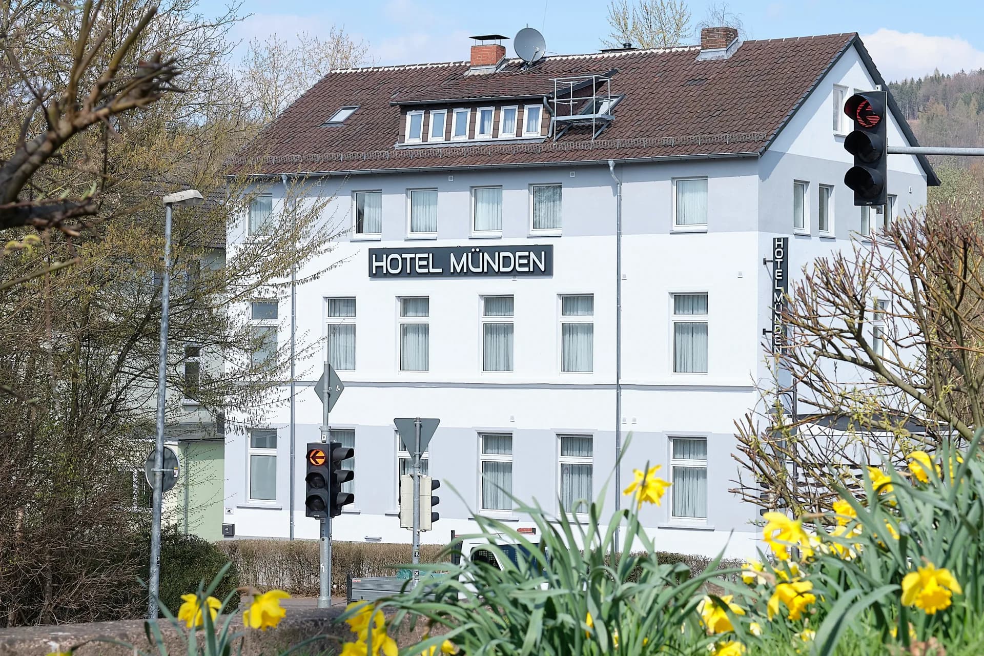 Außenansicht des Hotel Münden im Frühling mit blühenden Narzissen