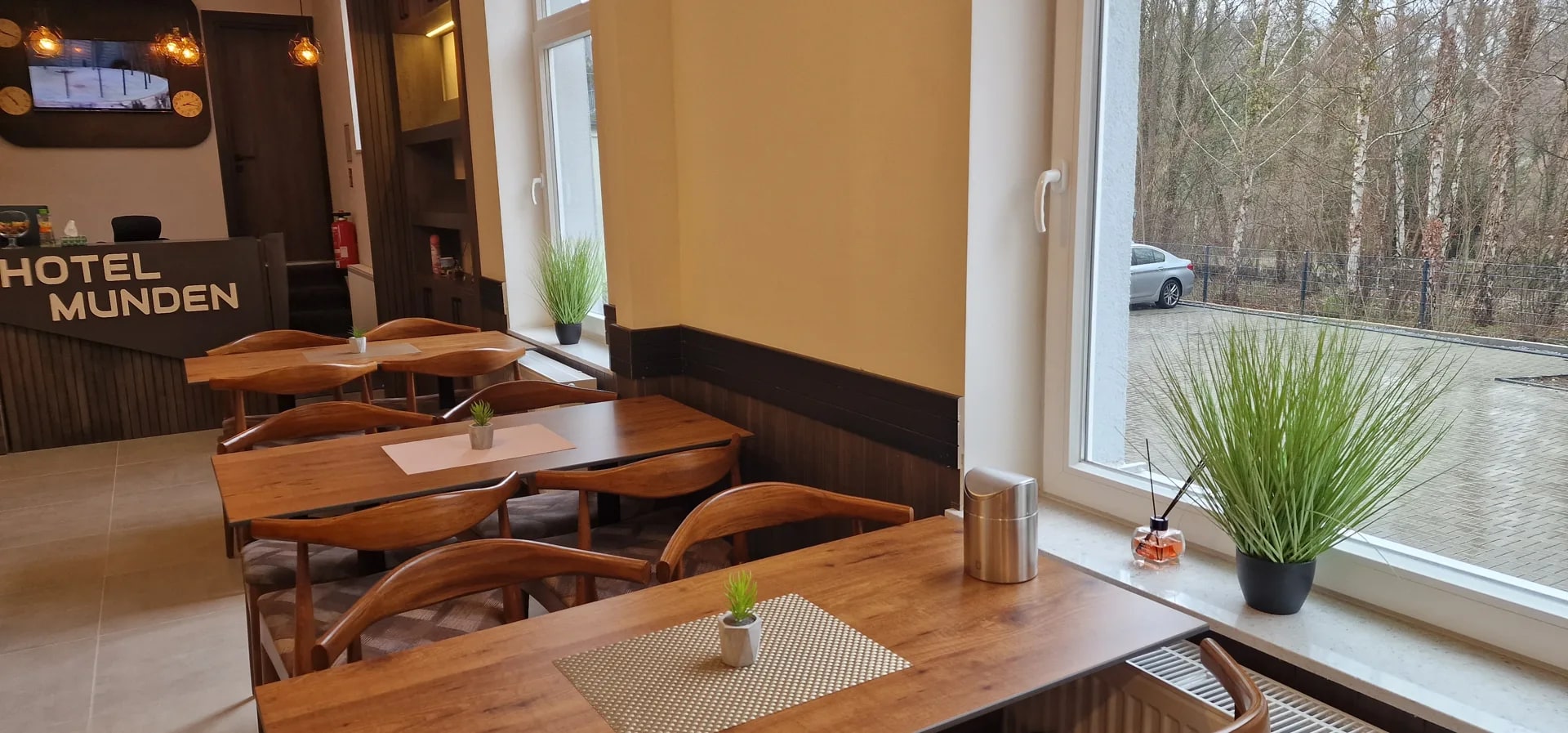 Frühstücksraum mit Fensterfront und Blick auf die hoteleigenen Parkplätze